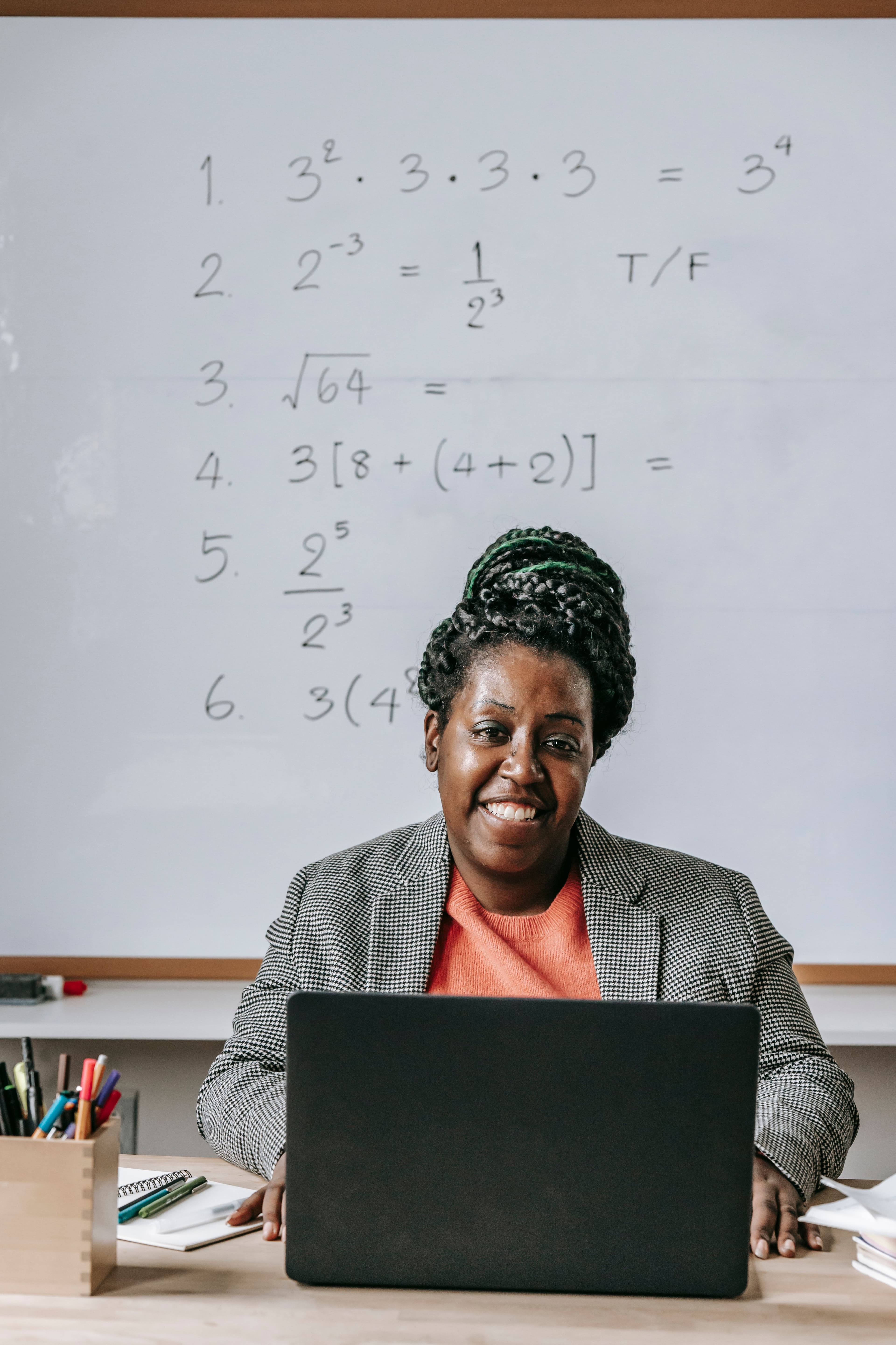 A qualified tutor teaching mathematics in front of a whiteboard